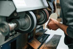 Polishing the outsole of the shoe. Man is working indoors photo