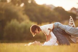 Kid in the hands of woman. Mother ,with her little daughter are on the summer field together photo