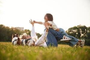 Kid is in hands of woman. Beautiful ,mother with her little daughter and dogs are on the summer field together photo