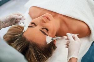 Brushes are, used to clean skin. Woman face getting facial care by beautician hands at spa salon photo