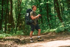Beautiful sunlight through ,the, trees. Tourist in summer forest. Conception of exploration and leisure photo