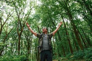 Enjoying the freedom, ,hands to the sides. Tourist in summer forest. Conception of exploration and leisure photo