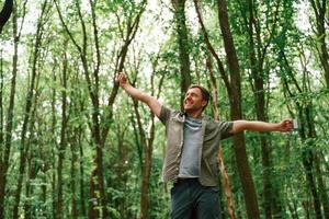 Enjoying the, freedom, hands to the sides. Tourist in summer forest. Conception of exploration and leisure photo