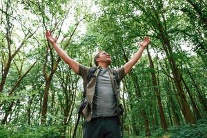 Enjoying ,the freedom, hands to the sides. Tourist in summer forest. Conception of exploration and leisure photo