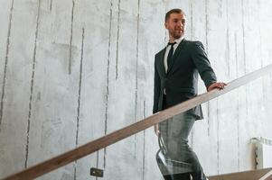 Man in, business suit and tie with case in hands is on the stairs photo