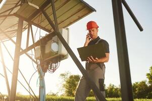 Maintenance by using laptop. Man is doing operating solar power plant photo