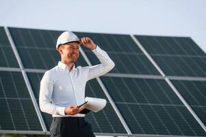 Notepad with document ,is ,in hands. Man is doing operating and maintenance in solar power plant photo