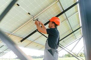 Fixes the wires.. Man is doing operating ,and maintenance in solar power plant photo