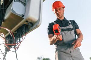 Checking ,the ,temperature ,by thermal imager. Man is doing operating and maintenance in solar power plant photo