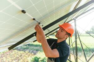 Fixes, the wires. Man is doing operating and maintenance in solar power plant photo
