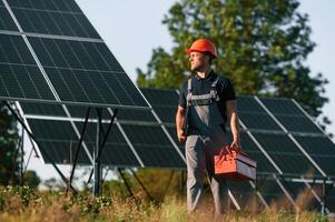 Red ,repair toolbox is in hands. Man is doing operating and maintenance in solar power plant photo