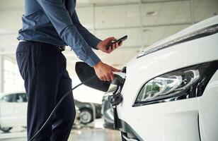 Close up view of man that is ,with, electrical car photo