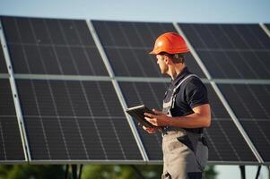 Table,t in hands. Man is doing operating and maintenance in solar power plant photo