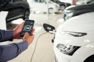 Information of charging process.,. Close up view of man that is with electrical car photo