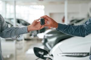 Man in, formal, clothes is with woman customer with the electric car photo