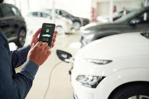 Information ,of ,charging process. Close up view of man that is with electrical car photo