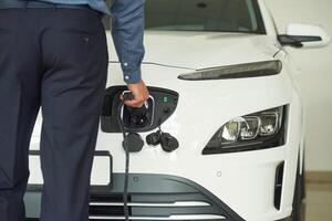 View from behind of man, with charger of man that is with electrical car photo