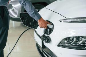 Putting, charger into electrical, car socket. Close up view of man photo