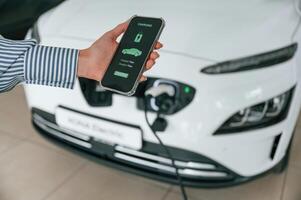 Conception ,of green energy.. Smartphone with charging process data. Close up view of woman photo