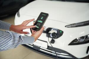 Conception of green, energy.. Smartphone with charging process data. Close up view of woman photo