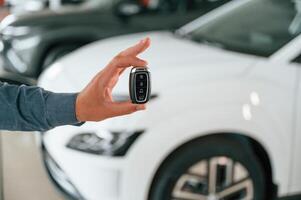Hand ,is, holding the keys. Close up view of man that is with electrical car photo