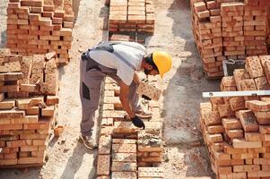 On ,the top of, the building with bricks. Handsome Indian man is on the construction site photo