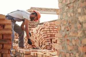 Bunch, of,, bricks. Placing them. Handsome Indian man is on the construction site photo
