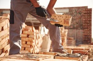 With brick in hands.. Close up view ,of ,man that is working on the construction site photo