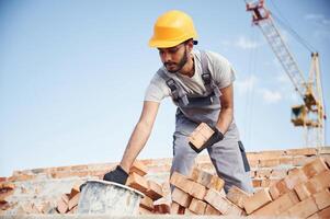 Blue sky and ,crane ,is behind. Handsome Indian man is on the construction site photo
