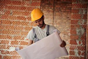 Holding, the document.. Handsome Indian man is on the construction site photo