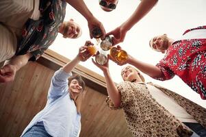 View ,from, below. Group of people are with beer in hands having good time photo