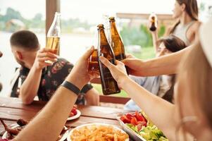Doing, cheers. Group ,of ,people are with beer in hands having good time photo