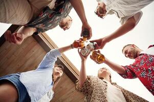 View from below. Group ,of people are with beer in hands having good time photo