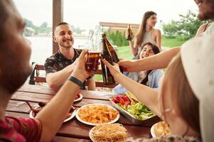 Doing, cheers. Group of people are with beer in hands having good time photo