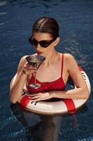With lifebuoy. Young woman, in red swimsuit, is in the pool photo
