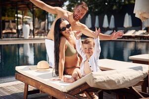 Conception ,of ,vacation. Happy family of father, mother and son are in the pool photo
