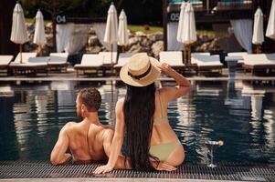 Rear view. Man with woman ,is in ,the pool together photo