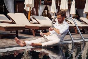 Holding newspaper.. Handsome ,man in ,formal clothes is in the pool photo