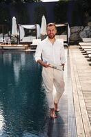 Business look, standing., Handsome, man in formal clothes is in the pool photo