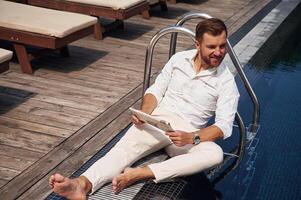 Holding newspaper. Handsome ,man in formal clothes is in the pool photo