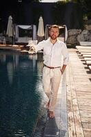 Handsome man in, formal ,clothes is in the pool photo