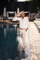 Business, look, standing. Handsome man in formal clothes is in the pool photo