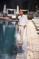 Business look,, standing,. Handsome man in formal clothes is in the pool photo