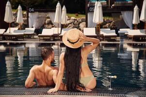 Rear view. Man with woman is ,in ,the pool together photo