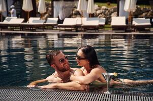 Embracing each ,other. Man with woman is in the pool together photo
