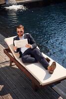 Holding, newspaper., Handsome man in formal clothes is in the pool photo