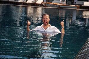 Handsome man in ,formal clothes is in the pool photo