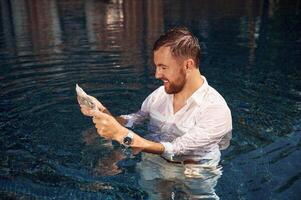 Handsome man, in formal clothes is in the pool photo