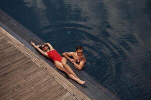 Vacation, time, top view. Man with woman is in the pool together photo