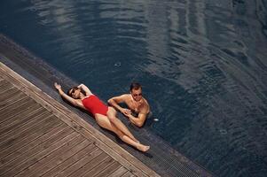 Vacation time, top, view. Man, with woman is in the pool together photo